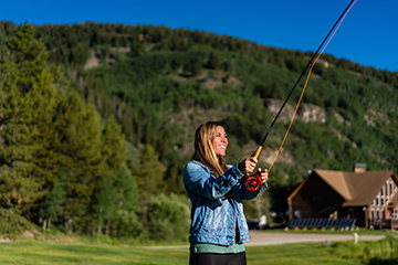 a person holding a kite while standing in the grass